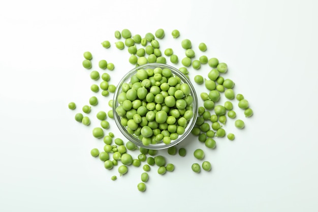 Bowl with pea seeds on white background