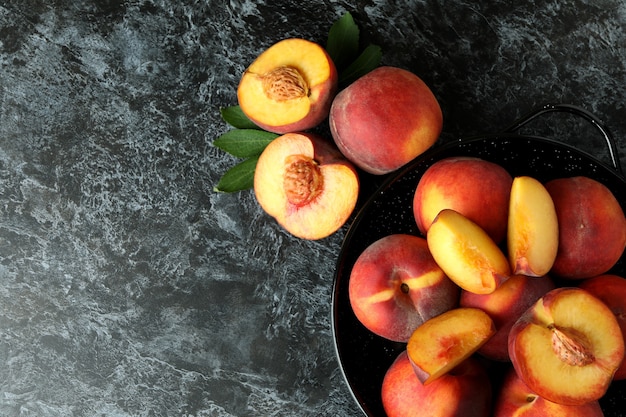 Bowl with peach fruits on black smokey table