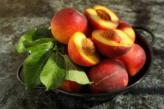 Bowl with peach fruits on black smokey table