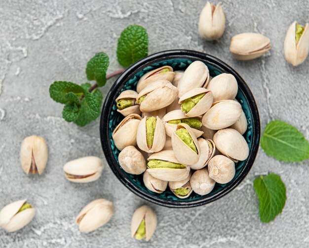 Bowl with pistachios on a grey concrete background