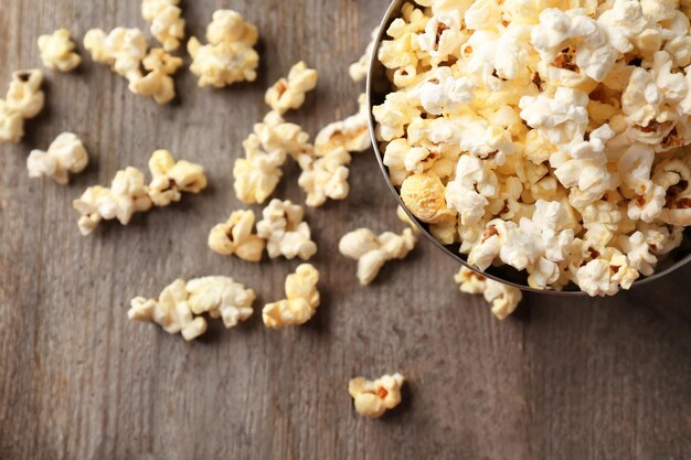 Bowl with popcorn on wooden table