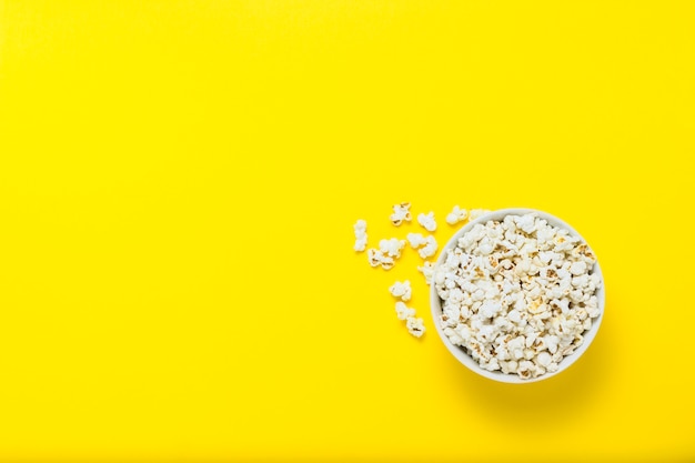 Bowl with popcorn on a yellow background. flat lay, top view.