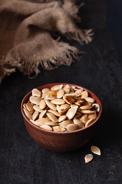 A bowl with pumpkin seeds dark photo