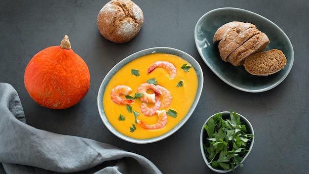 Bowl with pumpkin and shrimp cream soup, autumn food concept, top view.