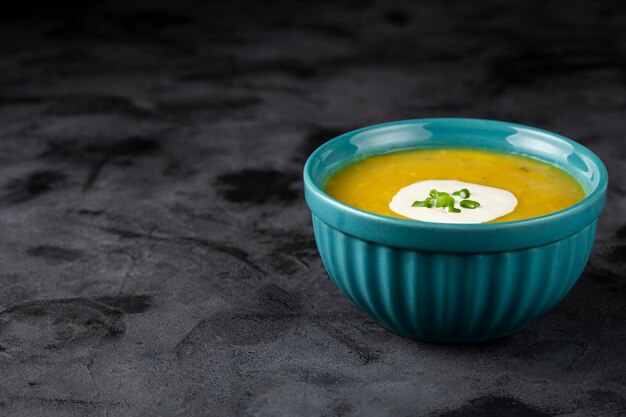 Bowl with pumpkin soup on the table.