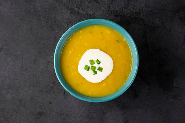 Bowl with pumpkin soup on the table.