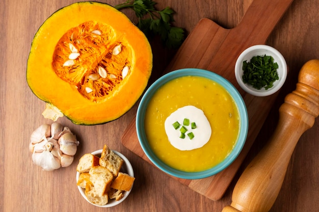 Photo bowl with pumpkin soup on the table.