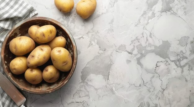 Bowl with raw potatoes and knife on light background