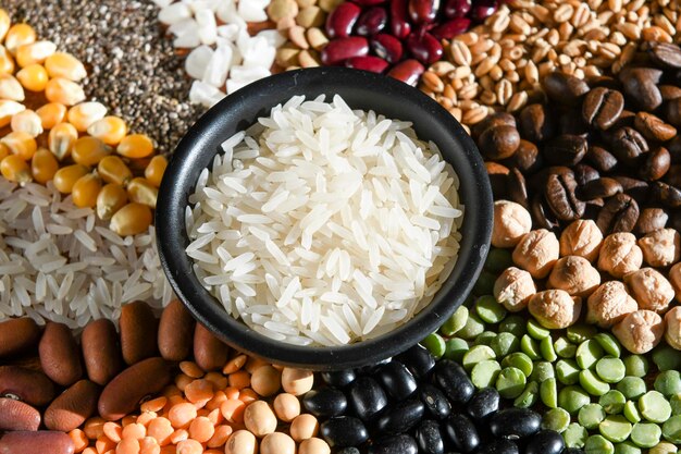 Bowl with raw white rices on various seeds grain