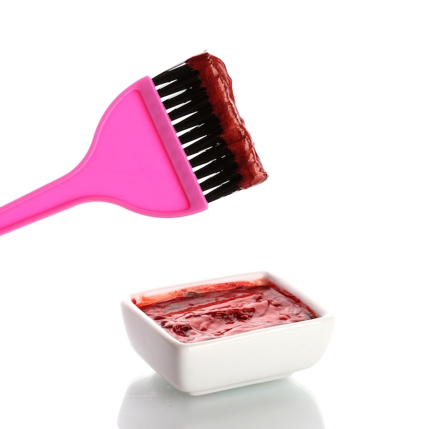 Photo bowl with red hair color and pink brush on white background