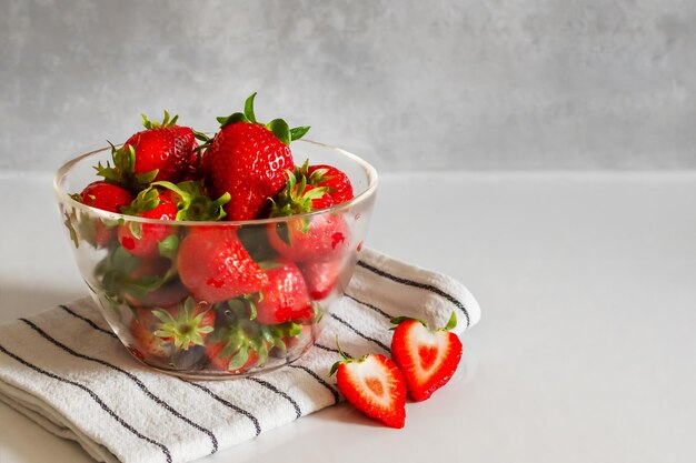 Bowl with red strawberries on the kitchen table cut strawberries copyspace on the right