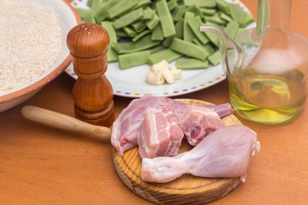 Bowl with rice plate with green beans and garlic table with meat oil and pepper prepared for cooking