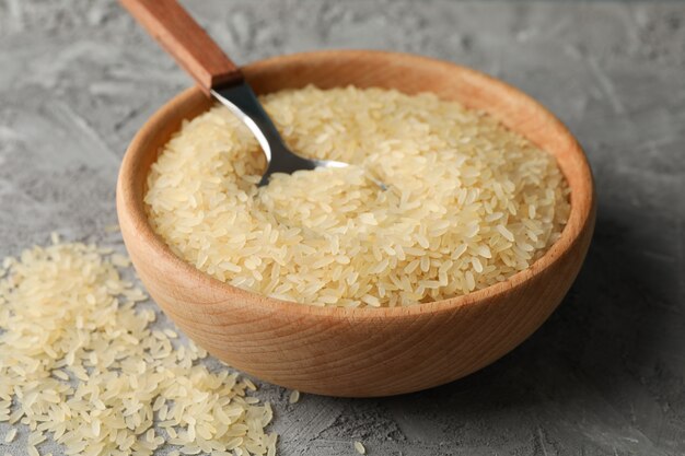 Bowl with rice and spoon on grey surface