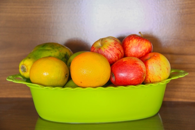 Bowl with ripe fruit, apple, orange, papaya