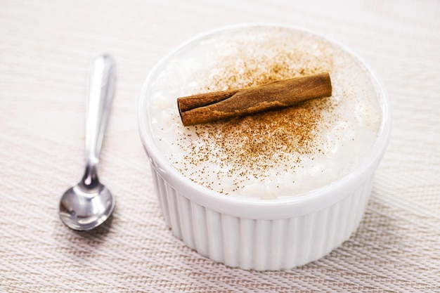 Bowl with sweet rice pudding with cinnamon stick and cinnamon powder homemade dessert typical sweet from Brazil at the June festivals