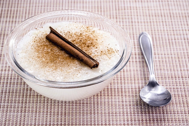 Bowl with sweet rice pudding with cinnamon stick and cinnamon powder homemade dessert typical sweet from Brazil