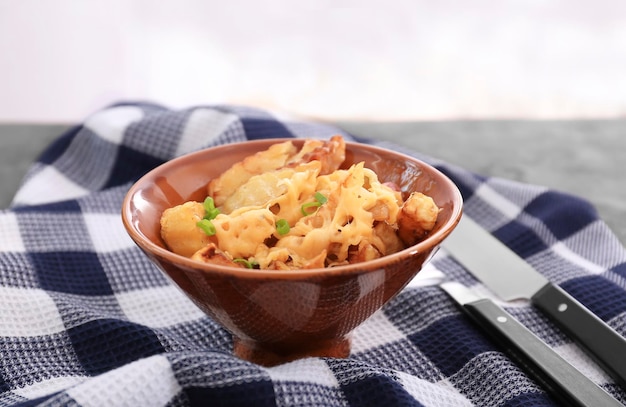 Bowl with tasty baked potato bacon and cheese on table