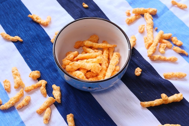 Bowl with tasty potato chips on wooden background