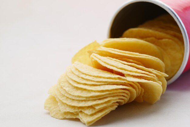 Bowl with tasty potato chips on wooden background .