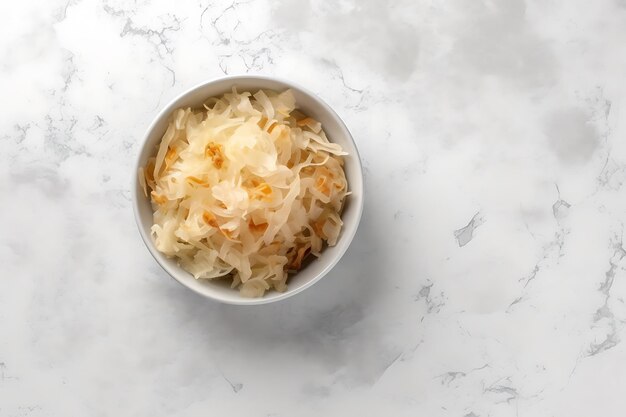 Bowl with tasty sauerkraut on white marble table top view Space for text