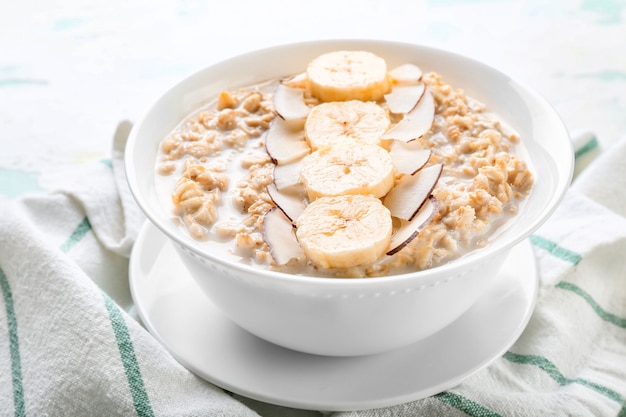 Bowl with tasty sweet oatmeal on table