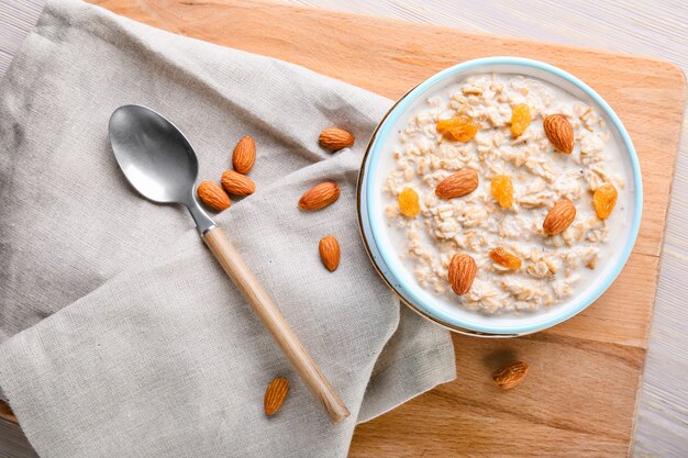 Bowl with tasty sweet oatmeal on table