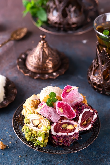 Bowl with various pieces of turkish delight lokum and black tea with mint