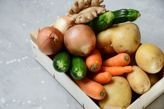 Bowl with vegetables on gray background