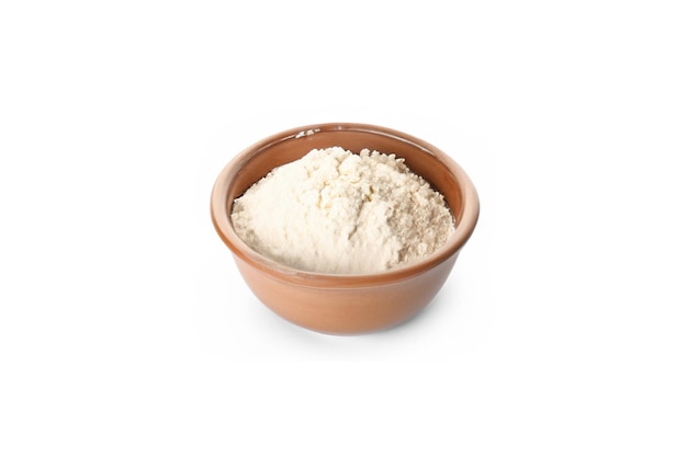 Bowl with wheat flour and spikelets on white background