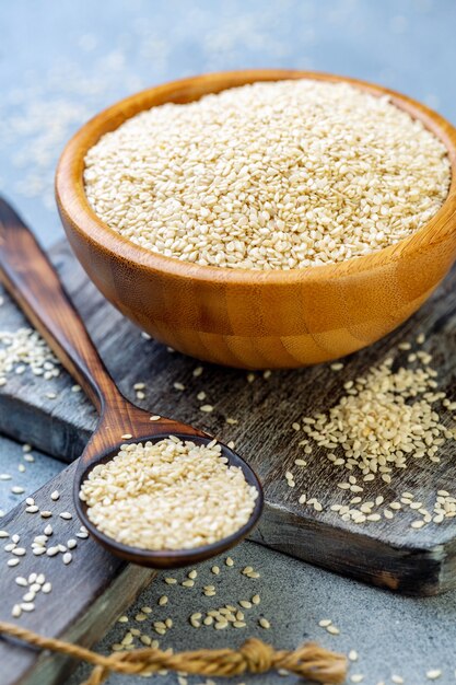 Bowl with white sesame seeds and wooden spoon