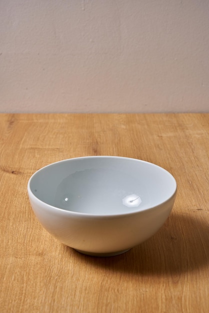 A bowl on a wooden table with a white background.