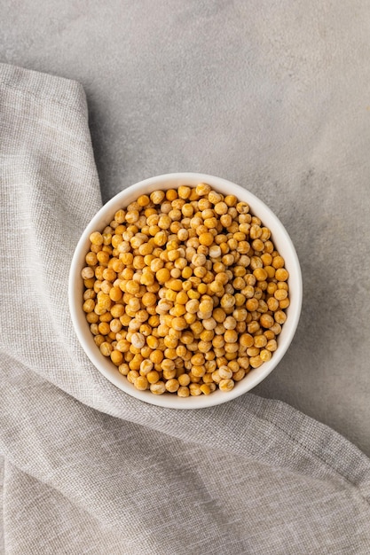 Photo a bowl of yellow dry peas on a light background