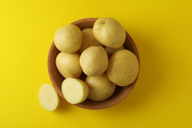 Bowl of young potato on yellow