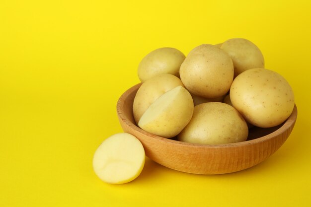 Bowl of young potato on yellow