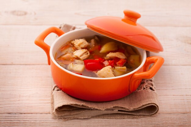 Bowl of yummy potato soup with bacon on wooden table