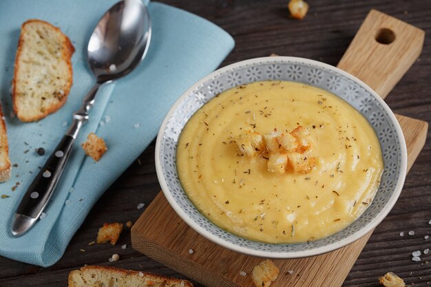 Bowl of zucchini and cauliflower cream soup on wooden table