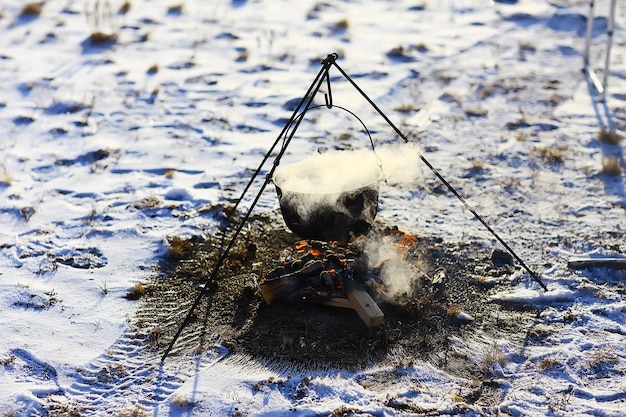 キャンプファイヤーの冬のハイキングに山高帽