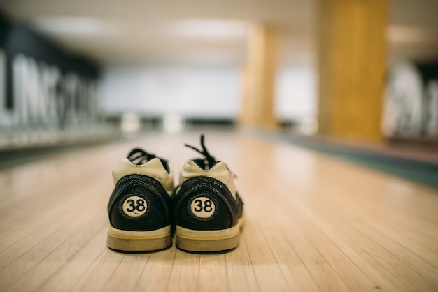 Bowling ball and house shoes on lane closeup view