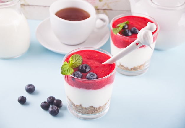 Photo bowls of breakfast healthy muesli with blueberry, strawberry and yogurt.