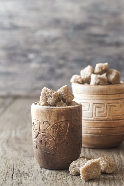 Bowls of brown sugar on the wooden background