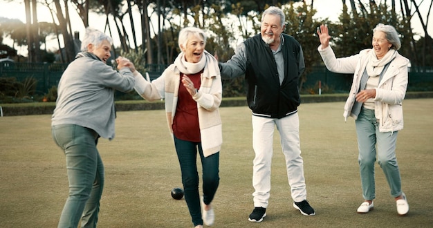 Photo bowls celebration and hugging with senior friends outdoor cheering together during a game motivation support or applause and a group of elderly people clapping while having fun with a hobby