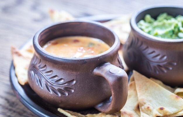 Bowls of guacamole and queso with tortilla chips