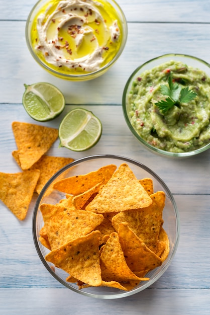 Bowls of hummus and guacamole with tortilla chips