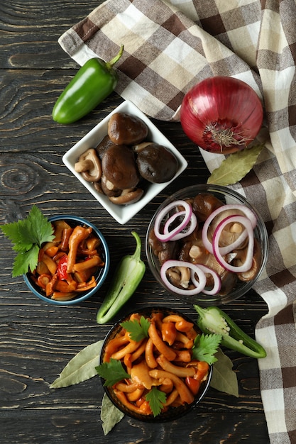 Bowls of marinated mushrooms on rustic wooden table