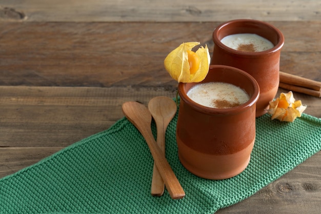 Bowls of rice pudding and cinnamon on a wooden background Copy space