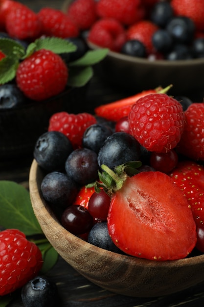 Bowls with berry mix on wooden table