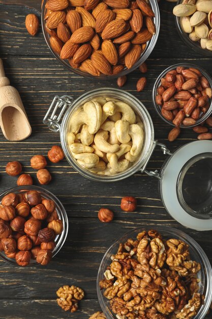 Bowls with different nuts on wooden table