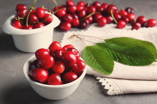 Bowls with fresh cherries on table