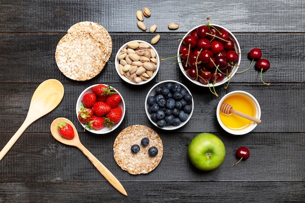 Bowls with fruits on wooden background