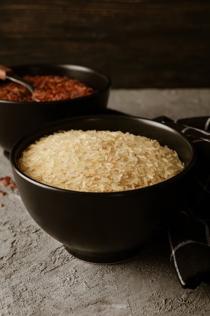 Photo bowls with rice, spoon and towel on grey table